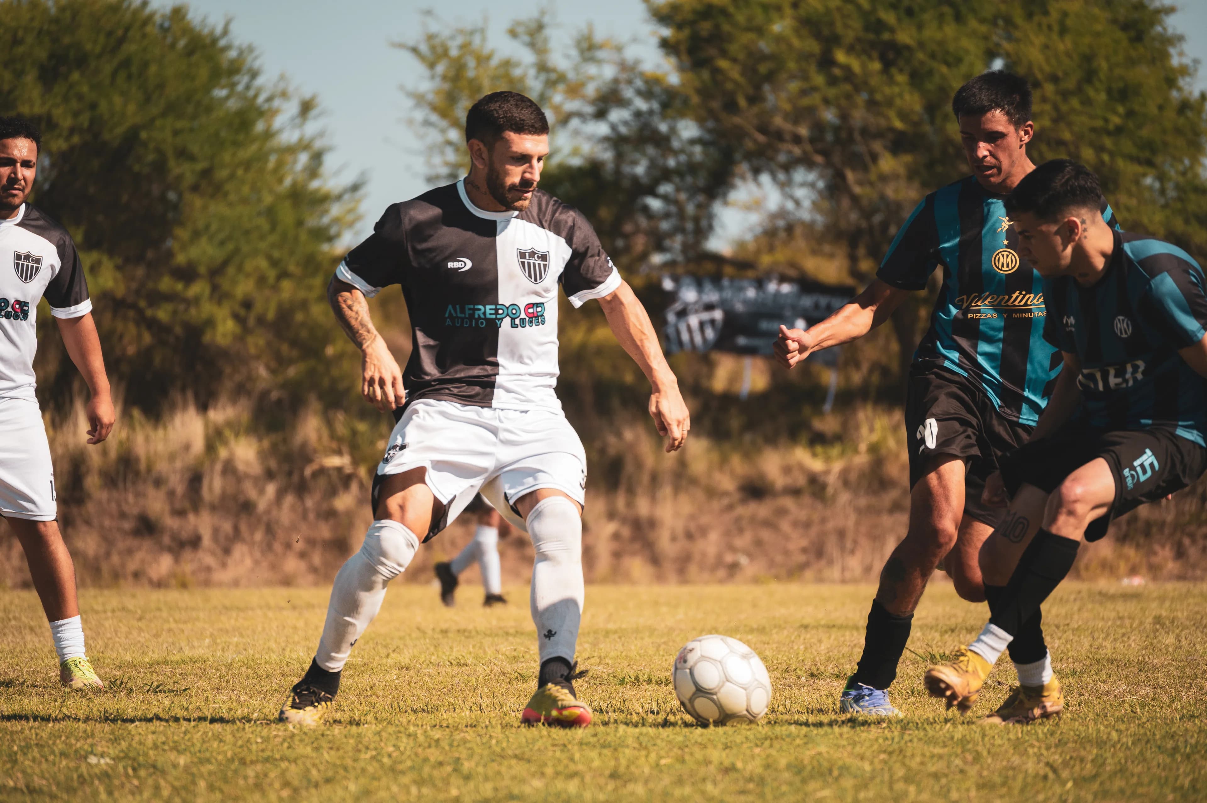 Jugador controlando la pelota ante la marca rival